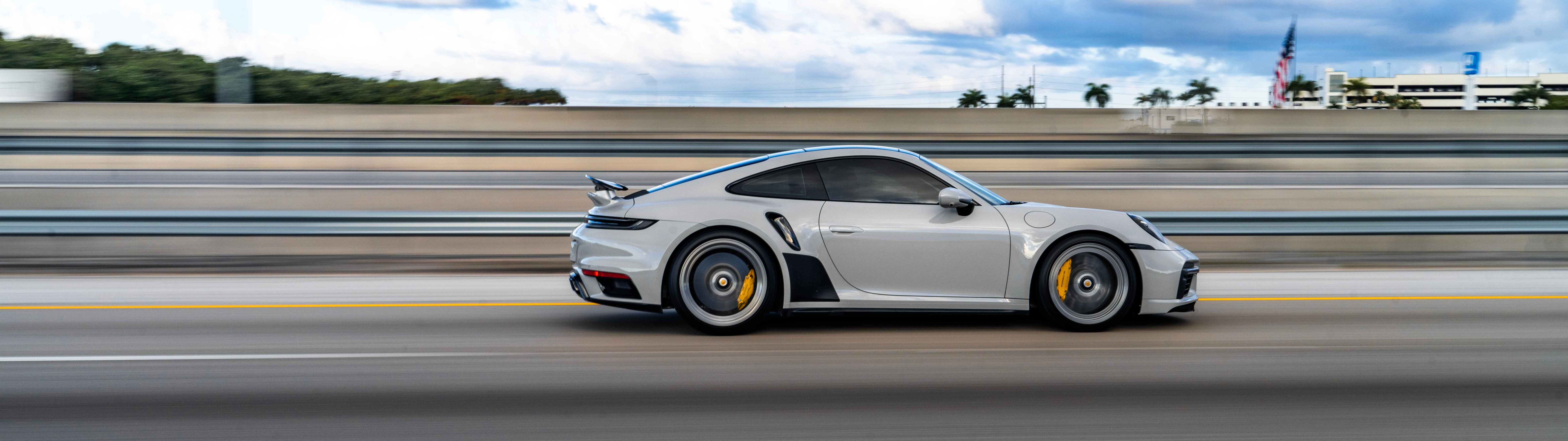 Крупный план роскошного спортивного автомобиля Porsche с элегантным дизайном и металлическим покрытием.