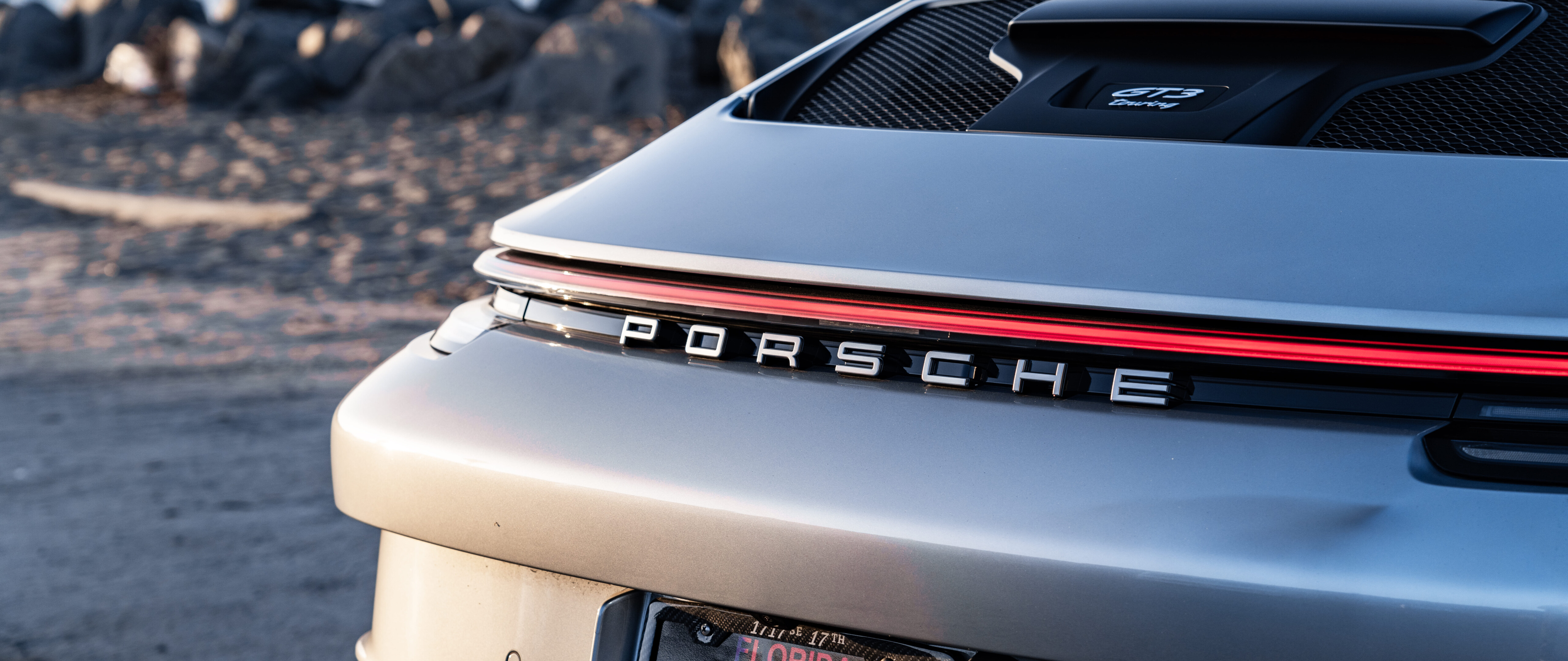 Высокопроизводительный спортивный автомобиль Porsche GT3 RS, отличающийся агрессивным аэродинамическим дизайном и изящным гоночным силуэтом.